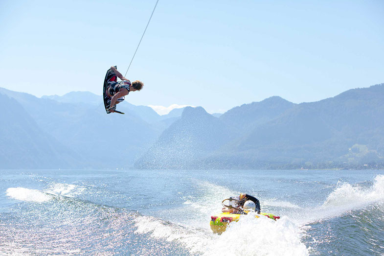 Wakeboarder in der Luft, darunter ein Tube-Fahrer