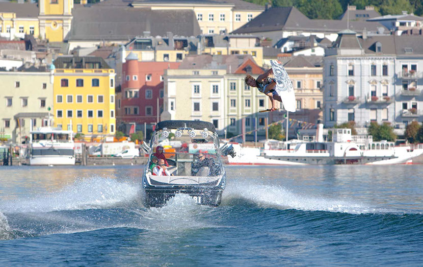 Sprung hinter dem Boot vor der Altstadt von Gmunden